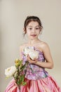 Beauty with peony. Beautiful girl dressed in a paper dress. Close-up portrait on a gray background. Royalty Free Stock Photo