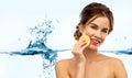 Young woman cleaning face with exfoliating sponge Royalty Free Stock Photo