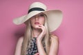 Beauty photo of attractive sensual woman wearing straw brimmed hat, posing on pink studio background. Girl with glamour Royalty Free Stock Photo