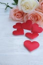 Beauty pink-orange roses and red satin hearts shape on wooden floor. Valentine's day background concept Royalty Free Stock Photo