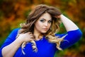 Beauty plus size model in blue dress outdoors, fat woman in autumn park among yellow leaves Royalty Free Stock Photo