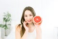 Beauty portrait of an attractive healthy woman standing isolated over light background, posing with half of juicy Royalty Free Stock Photo