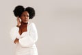 Beauty portrait of attractive woman with afro hairstyle and delicate makeup looking away, posing over studio background Royalty Free Stock Photo