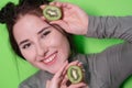 Beauty portrait of attractive young woman with clean radiant skin face with kiwi halves, brunette girl with bare Royalty Free Stock Photo