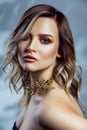 Beauty portrait of beautiful fashion model with makeup, colored wavy hairstyle and accessories on her neck. Royalty Free Stock Photo