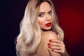 Beauty portrait of blonde woman with red lips, long healthy shiny blond hair style and manicured nails looking at camera. Sensual Royalty Free Stock Photo