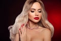 Beauty portrait of blonde woman with red lips, long healthy shiny blond hair style and manicured nails looking at camera. Sensual Royalty Free Stock Photo