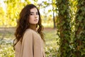 Beauty portrait of a confident girl with curly brunette hair in elegant suit, outdoors, in the park Royalty Free Stock Photo