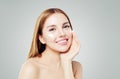 Beauty portrait of cute young woman smiling while applying some facial cream on her cheek Royalty Free Stock Photo