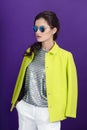 Beauty portrait of a fashion model in sunglasses, young woman in a trend clothes, isolated purple background. Royalty Free Stock Photo
