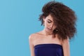 Beauty portrait of girl with afro hairstyle. Girl posing on blue background. Studio shot. Copy Space. Royalty Free Stock Photo