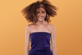 Beauty portrait of girl with afro hairstyle. Girl posing on yellow background, looking at camera, smiling. Studio shot Royalty Free Stock Photo