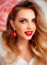 Beauty Portrait of girl with perfect makeup and red jewelry. Beautiful model woman with long curly hairstyle. Eyelashes. Cosmetic Royalty Free Stock Photo