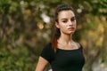 Beauty portrait of a girl with ponytail hair, dressed in black dress, being on the balcony in summer day.