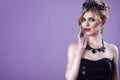 Beauty portrait of gorgeous young blond model in strapless sequin top with updo hair and black jewel crown on her head