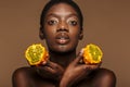 Beauty portrait of half-naked african woman holding kiwano horned melon