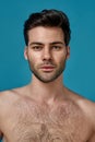 Beauty portrait of handsome naked brunette man with fresh perfect smooth skin looking at camera, posing isolated over