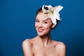 Beauty portrait of happy woman with the lily flower on blue Royalty Free Stock Photo
