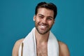 Beauty portrait of joyful bearded man with towel around neck smiling at camera with toothpaste in his mouth after Royalty Free Stock Photo