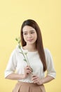 Beauty portrait of lady 20s holding white lisianthus flowers over yellow background Royalty Free Stock Photo