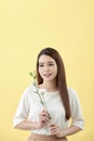 Beauty portrait of lady 20s holding white lisianthus flowers over yellow background Royalty Free Stock Photo