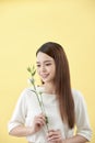 Beauty portrait of lady 20s holding white lisianthus flowers over yellow background Royalty Free Stock Photo