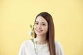 Beauty portrait of lady 20s holding white lisianthus flowers over yellow background Royalty Free Stock Photo