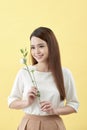 Beauty portrait of lady 20s holding white lisianthus flowers over yellow background Royalty Free Stock Photo