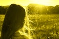 Beauty portrait of a little girl with long hair enjoying nature outdoors, on a field with daisies. The wind blows the girl`s long Royalty Free Stock Photo