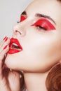 Beauty portrait of sexy women with glamour make up. Red lips and red eyeshadows, neils. Beauty fashion model face. Manicured hand Royalty Free Stock Photo