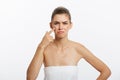 Beauty portrait of a shocked young half naked woman examining her face while looking at the mirror isolated over white Royalty Free Stock Photo