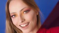 Beauty portrait shot. Young caucasian woman with big smile, make up and red film gel in front of her face. Diagonal Royalty Free Stock Photo