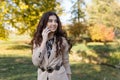 Smiling girl in elegant suit talking on phone. Outdoor portrait of long-haired woman in beige jacket laughing. Royalty Free Stock Photo