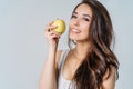 Beauty portrait of smiling young asian woman girl holding green apple near clean face on grey background Royalty Free Stock Photo