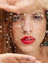 Beauty portrait of woman behind wet window Royalty Free Stock Photo