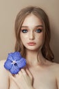 Beauty portrait of a woman with a blue Vanda Orchid in her hand. Natural cosmetics made of flower petals, clean delicate skin of Royalty Free Stock Photo