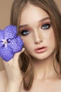 Beauty portrait of a woman with a blue Vanda Orchid in her hand. Natural cosmetics made of flower petals, clean delicate skin of Royalty Free Stock Photo