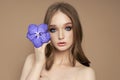 Beauty portrait of a woman with a blue Vanda Orchid in her hand. Natural cosmetics made of flower petals, clean delicate skin of Royalty Free Stock Photo