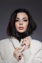 Beauty portrait of woman in white sweater, perfect evening makeup on dark background. Perfect skin without wrinkles, professional Royalty Free Stock Photo