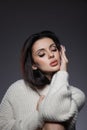 Beauty portrait of woman in white sweater, perfect evening makeup on dark background. Perfect skin without wrinkles, professional Royalty Free Stock Photo