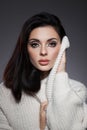 Beauty portrait of woman in white sweater, perfect evening makeup on dark background. Perfect skin without wrinkles, professional Royalty Free Stock Photo