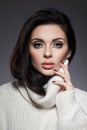 Beauty portrait of woman in white sweater, perfect evening makeup on dark background. Perfect skin without wrinkles, professional Royalty Free Stock Photo