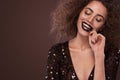 Beauty portrait of young african american girl with afro hairstyle and chocolate . Girl posing on brown background Royalty Free Stock Photo