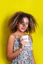 Beauty portrait of young african american girl with afro hairstyle. Girl posing on yellow background, looking at camera. Royalty Free Stock Photo