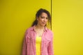 Beauty portrait of young african american girl with afro hairstyle. Girl posing on yellow background, looking at camera Royalty Free Stock Photo