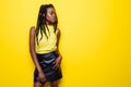 Beauty portrait of young african american girl with afro hairstyle. Girl posing on yellow background, looking at camera, smiling. Royalty Free Stock Photo