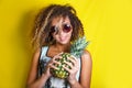 Beauty portrait of young african american girl with afro hairstyle in sunglasses. Girl posing on yellow background, looking at cam Royalty Free Stock Photo