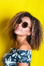 Beauty portrait of young african american girl with afro hairstyle. Girl posing on yellow background, looking at camera. Studio sh Royalty Free Stock Photo