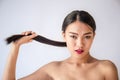 Beauty portrait of young asian woman with her hand pulling her long black hair Royalty Free Stock Photo