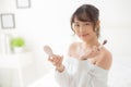 Beauty portrait young asian woman smiling with face looking mirror applying makeup with brush cheek in the bedroom